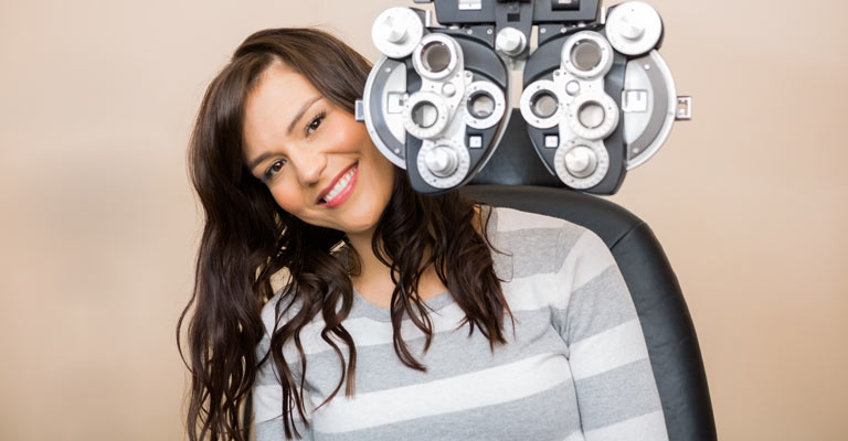 A woman sitting behind a vision exam machine